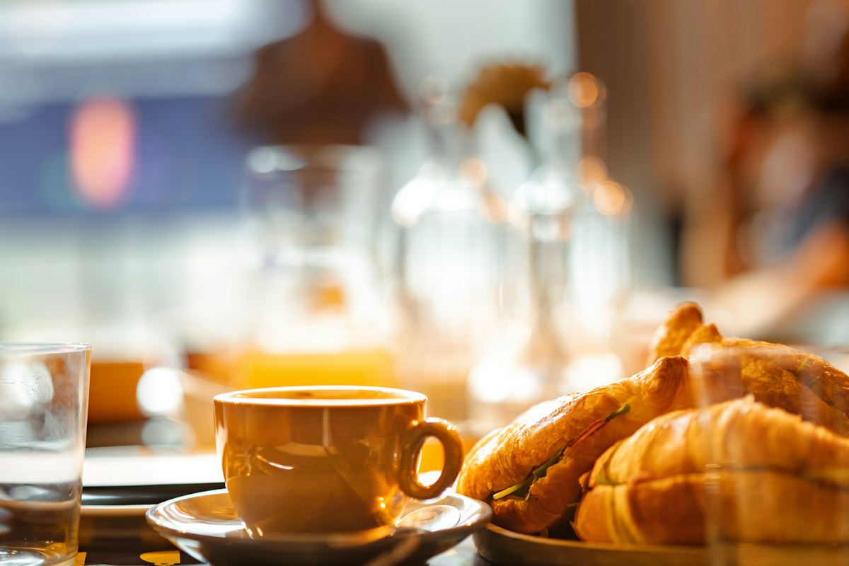 Croissants on a plate beside a cup of coffee